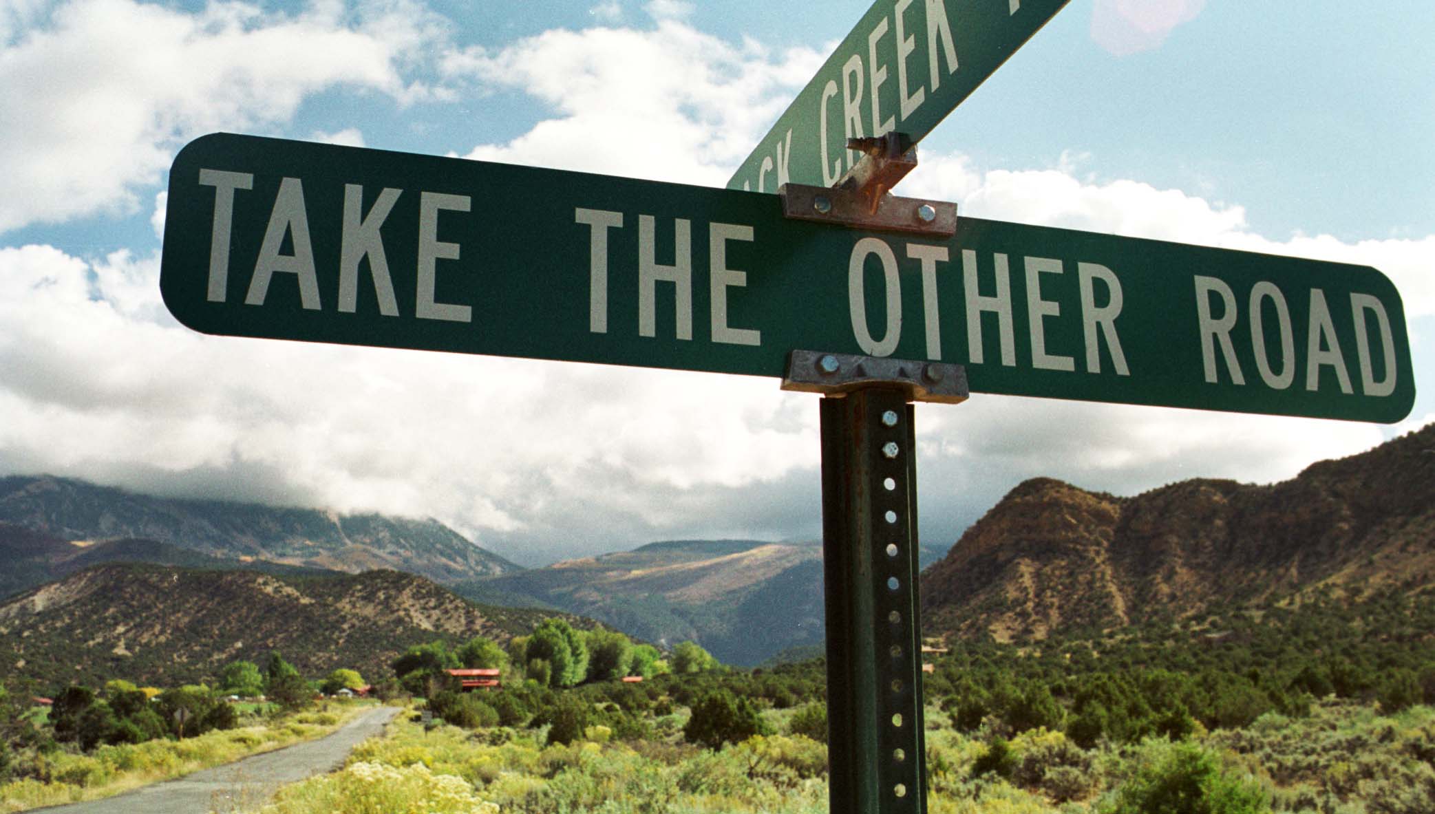 a road sign that reads - take the other road